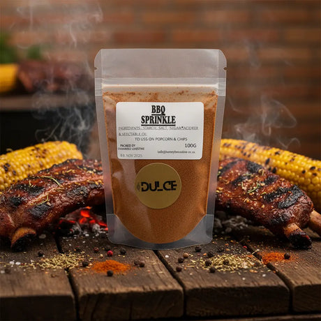Packaged BBQ sprinkle with grilled ribs and corn on a wooden surface