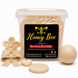 A clear plastic tub of Honey Bee confectionery product with a black label, shown with several beige decorative pieces including a flower, bow, heart, oval, and round disc on a white background.