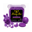 A clear plastic tub filled with purple wax melts, labeled 'Honey Bee Lifestyle', shown with purple wax flower and butterfly decorations and a round purple lid on a white background.