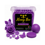 A clear plastic tub filled with purple wax melts, labeled 'Honey Bee Lifestyle', shown with purple wax flower and butterfly decorations and a round purple lid on a white background.