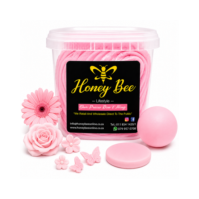 A clear plastic tub filled with pink rolled wax melts, shown with a black front label reading Honey Bee. Surrounding the tub are pink decorative flowers, a pink beeswax melt ball, a round lid, and small pink wax flower and butterfly shapes on a white background.