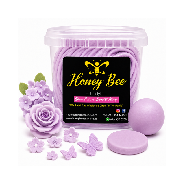 A clear plastic tub filled with lavender-colored wax melts, shown with a black front label reading Honey Bee Lifestyle. Surrounding the tub are lavender wax flower and butterfly ornaments, a lavender wax ball, and a round lavender wax disc, all on a white background.