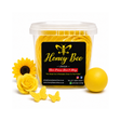 A clear plastic tub filled with yellow decorative items, featuring a black Honey Bee label, styled with yellow sunflowers, a yellow rose, small yellow butterflies, and a yellow ball on a white background.