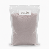 A clear resealable stand-up pouch filled with a pale pink cake mix, labeled 'Honey Bee Red Velvet Cake Mix' on a white background.