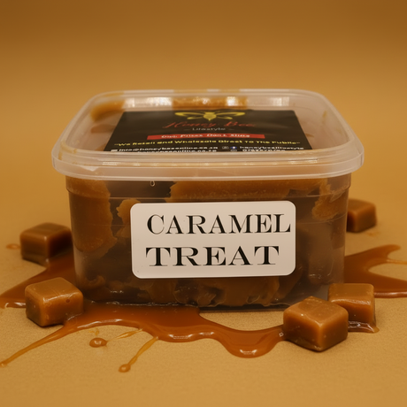 A clear plastic tub of caramel treat with a white label reading 'CARAMEL TREAT' and a black lid label, styled with caramel drizzle and caramel cubes on a tan background.