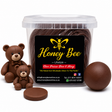 A clear plastic tub filled with dark brown chocolate-covered treats, with two small teddy bear figurines, a round chocolate piece, and a loose chocolate ball placed beside it on a white background. The front label reads Honey Bee Lifestyle.