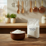 Bag of Honey Bee Corn Flour next to a bowl on a kitchen counter with utensils in the background