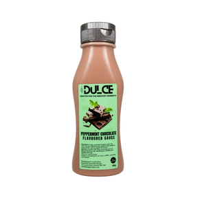 A bottle of Dulce Peppermint Chocolate Flavoured Sauce on a plain white background. The bottle is filled with a light brown chocolate-colored sauce and features a light green label with an illustration of chocolate pieces and mint leaves, topped with a silver cap.